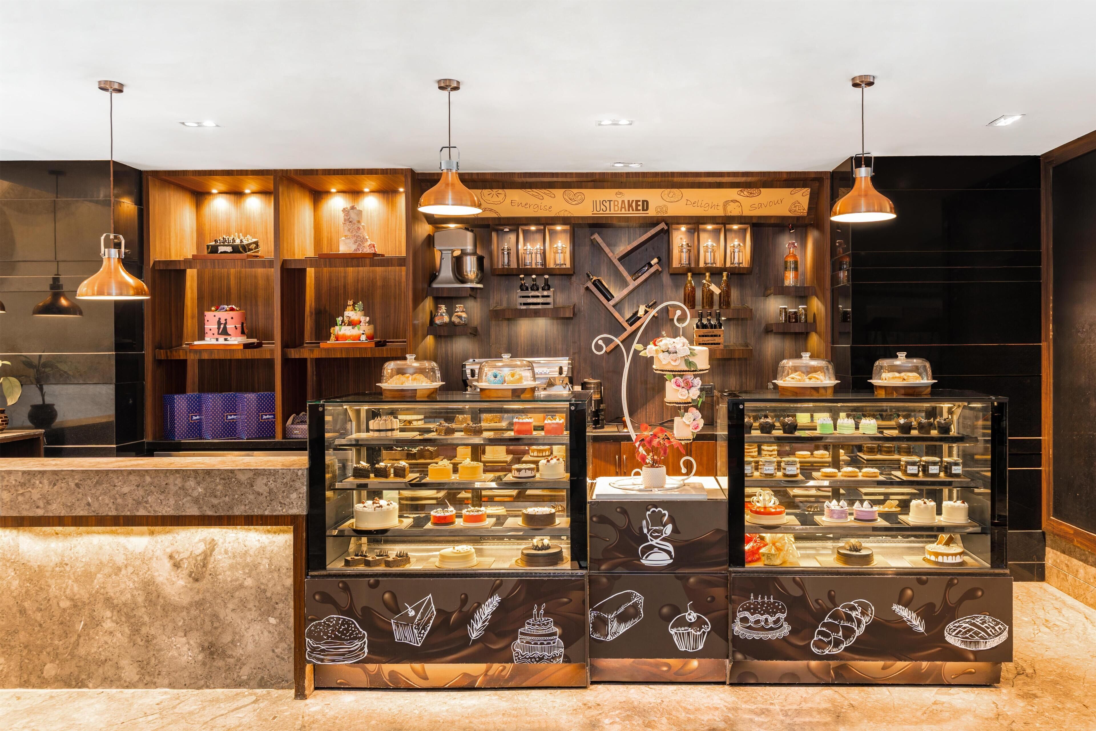 Una vitrina de panadería con diversos productos horneados y una batidora.