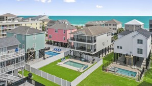 Un quartier résidentiel avec des maisons, une piscine et une vue sur l’océan.