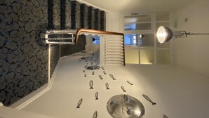 En trappe med et mønstret tæppe, gelænder i metal og en lampe.