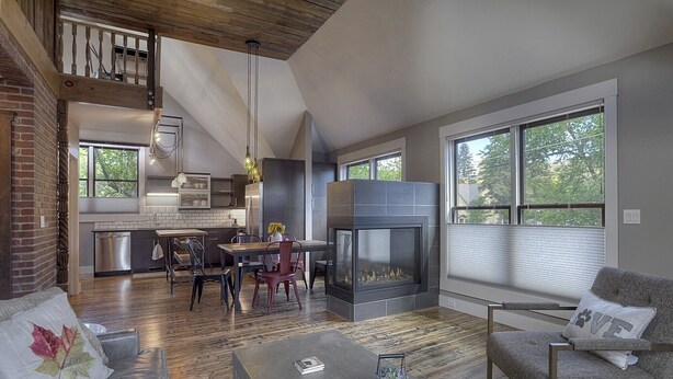 A spacious living area with a fireplace, a dining table, and a sofa.