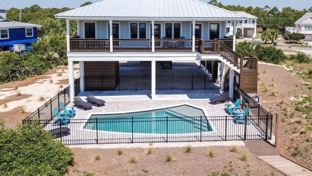 Une maison à deux étages avec une piscine et un balcon.