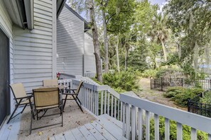 Enjoy outdoor dining or relaxation on this deck overlooking a lush garden.