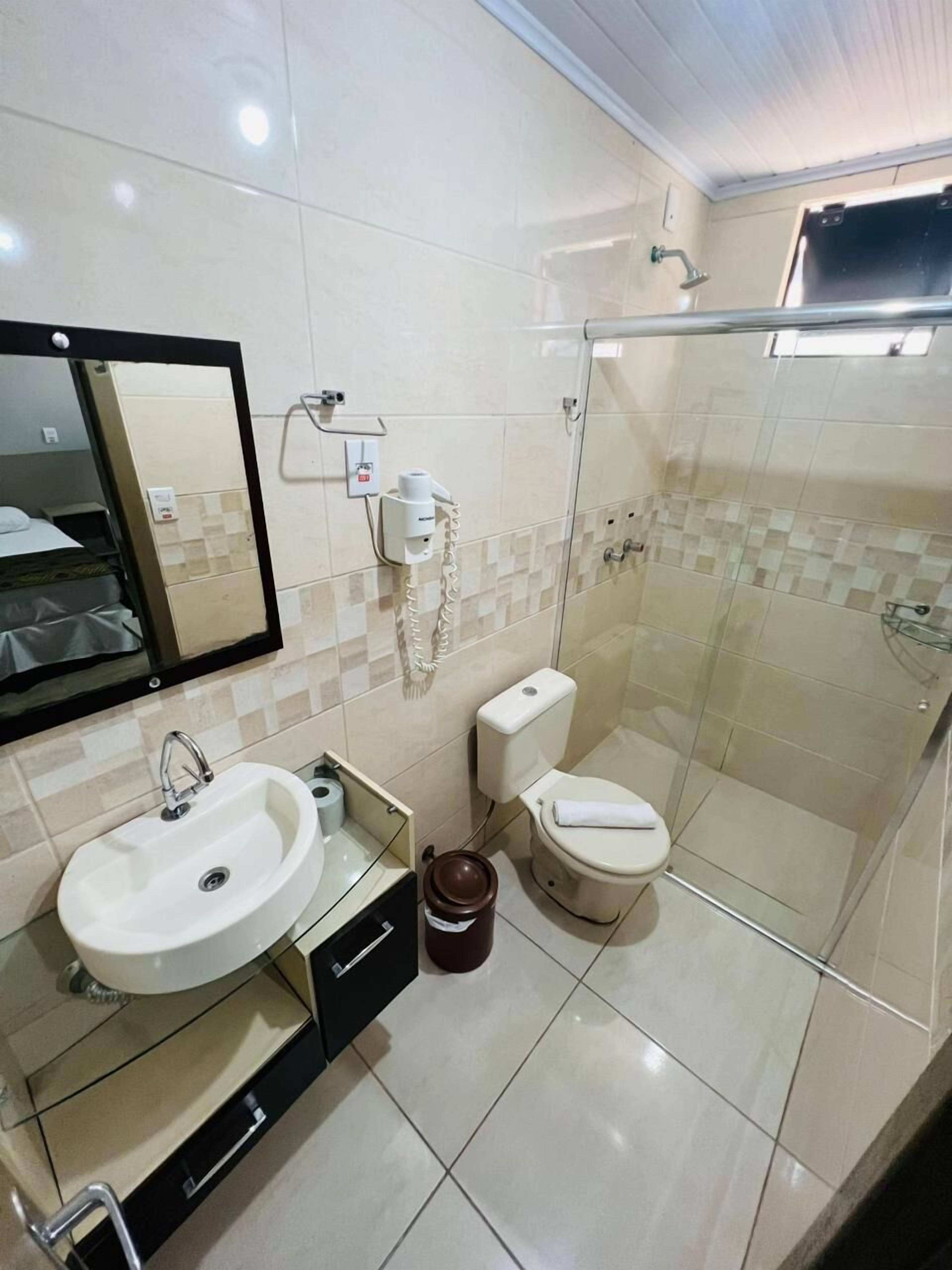 Un baño moderno con lavamanos, inodoro y ducha.