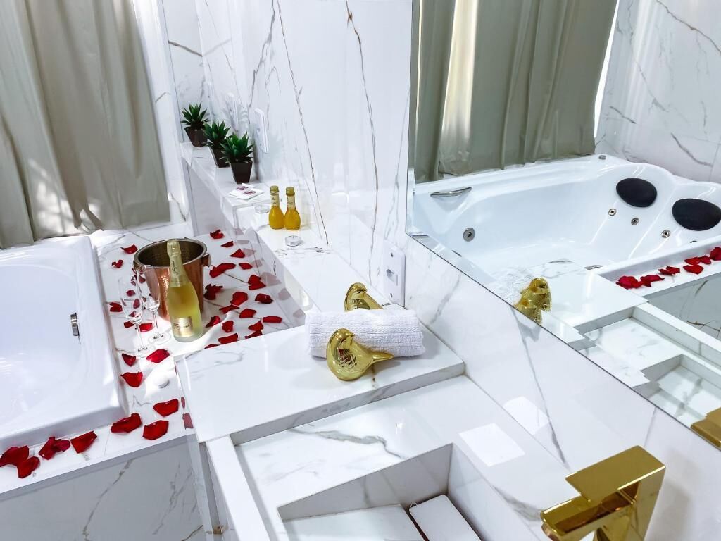 A luxurious bathroom with a large bathtub, a sink, and a mirror.