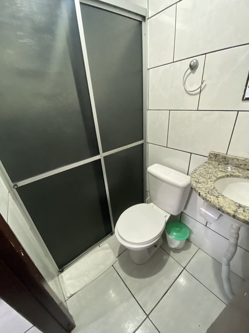 Une salle de bain équipée de toilettes, d’un lavabo et d’une poubelle.