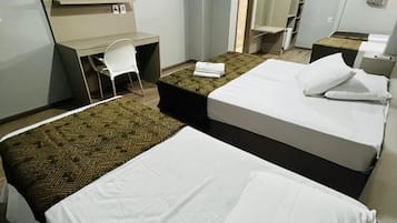 A hotel room with two beds, a desk, a chair, a TV, and a mirror.