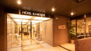 A hotel entrance with a sign reading "HOTEL SUNROUTE".