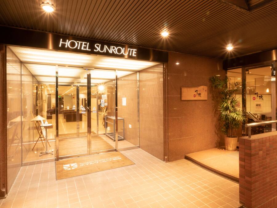 A hotel entrance with a sign reading "HOTEL SUNROUTE".