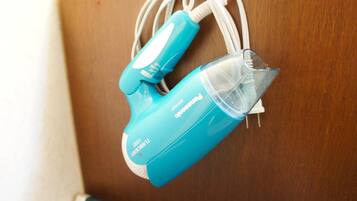 Purificador d'aire portàtil blau amb filtre de pols transparent, connectat a un cable d'alimentació blanc, damunt una superfície de fusta.
