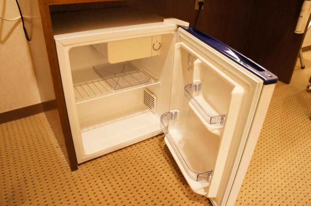 An open refrigerator with two shelves and a freezer compartment.