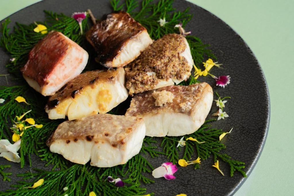 A plate of cooked fish with herbs and flowers.