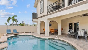 A swimming pool with lounge chairs and a patio area. - Pet Friendly with Private Pool 3BR Casa Del Sol Breeze (Fort Myers Beach)