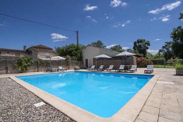 A rectangular swimming pool with a tiled edge, surrounded by a gravel area. - Charming rural double cottages - private pool and park (Montreal du Gers)