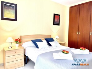 A hotel room with a bed, bedside tables, a wardrobe, and a framed picture on the wall.