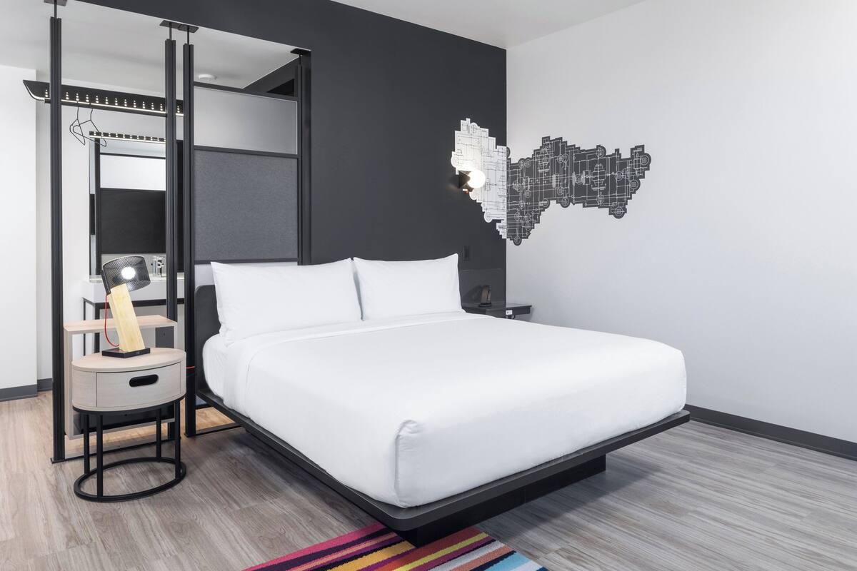 Une chambre moderne avec un lit, un bureau et une carte accrochée au mur.