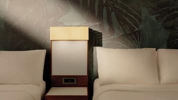 A hotel room with a bed, a nightstand, and a wall with a leaf pattern.