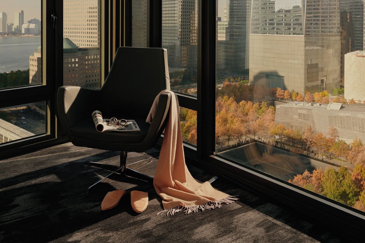 A modern room with a large window overlooking a cityscape and a river.