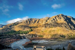 Surrounded by majestic mountains, this serene retreat offers breathtaking views of a tranquil river valley.