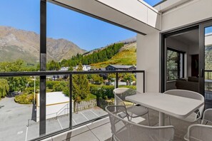 Enjoy breathtaking views of the surrounding mountains from this balcony with a table and four chairs.