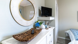 A bedroom with a bed, a television on a stand, a dresser, and a mirror. - Stunning Gulf-Front/Balcony Views + Hot Tub/Top-Rated 10/10/Pensacola Beach (Pensacola Beach)