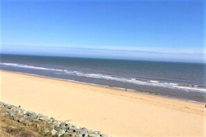 A beach with a clear sky and calm sea.