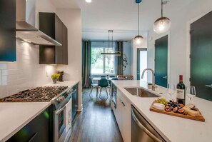 Cozinha moderna com ilha central, eletrodomésticos de aço inoxidável e área de jantar com vista.