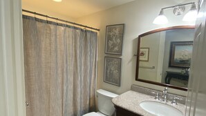Een badkamer met toilet, wastafel en douchegordijn.