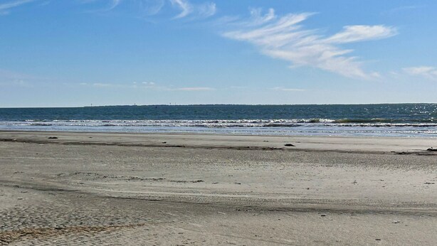 A beach with a clear sky and calm sea. - South Beach Dog-friendly Waterfront Villa (Hilton Head Island)
