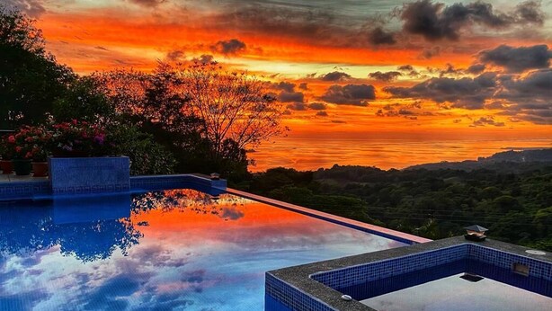 An infinity pool with a view of a sunset over a mountainous landscape. - Perfect viewing of migrating Pacific whales, from the hills above Ojochal (Ojochal)