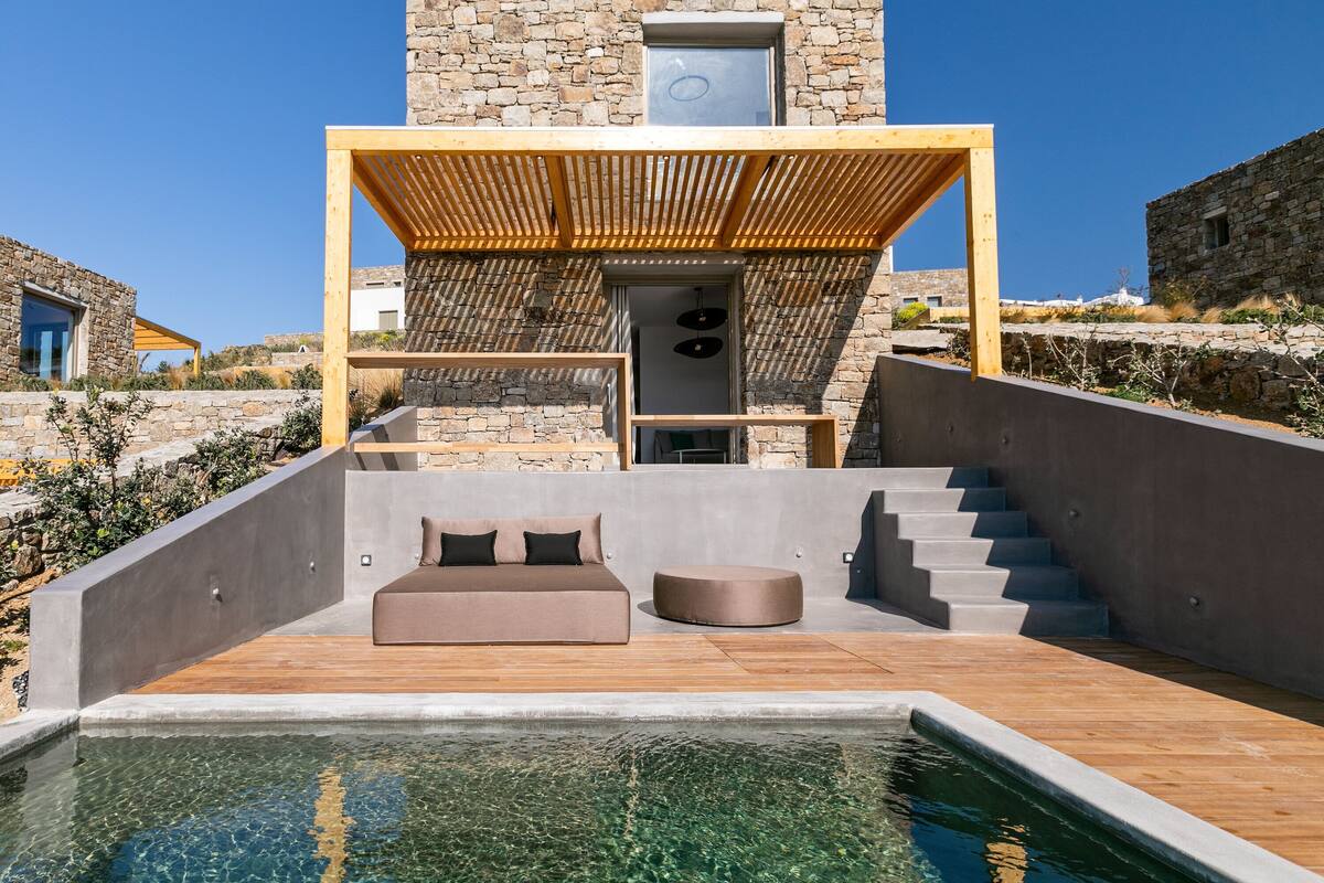 A modern outdoor pool area with a stone building in the background.