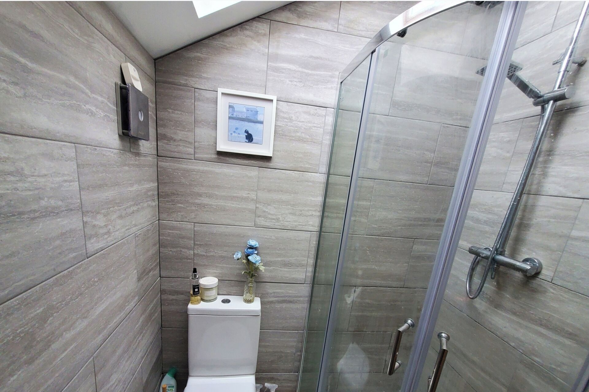 A modern bathroom with a shower, a toilet, and a sink.