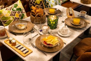 Desayuno con cruasanes, fruta y café.