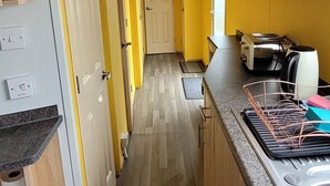 Eine schmale Küche mit Holzausstattung, einer Arbeitsplatte und einem Spülbecken.