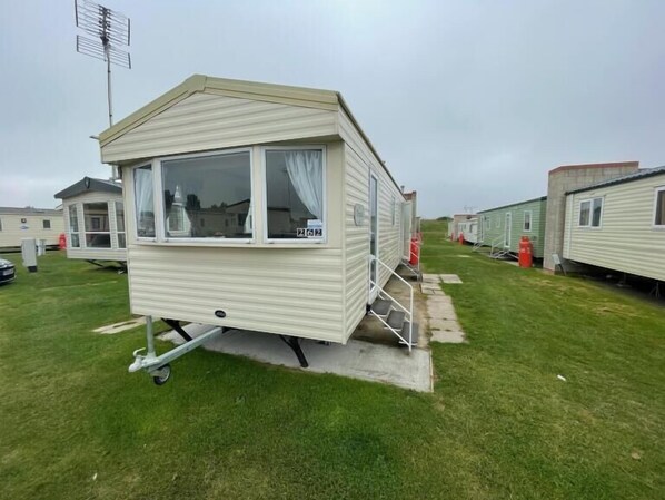 Een kleine mobiele woning met een raam, een klein terras en nummer 262.