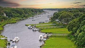 En flod med både ved kaj, omgivet af frodig vegetation og en bro, der forbinder bredderne.