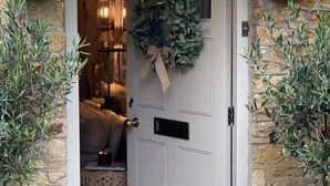 A door with a wreath, a small step leading inside, and two potted plants on either side. - Stunning Interior designed cottage (Chipping Campden)