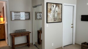 A hallway with a wooden console table, a framed sign, a mirror, and a door. - Cozy Oro Valley Retreat, close to Golf, Trails & Fine Dining-Dog Friendly (Tucson)