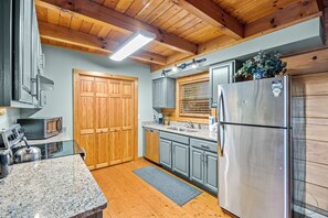 Una cocina con armarios de madera, un refrigerador de acero inoxidable y un horno empotrado.