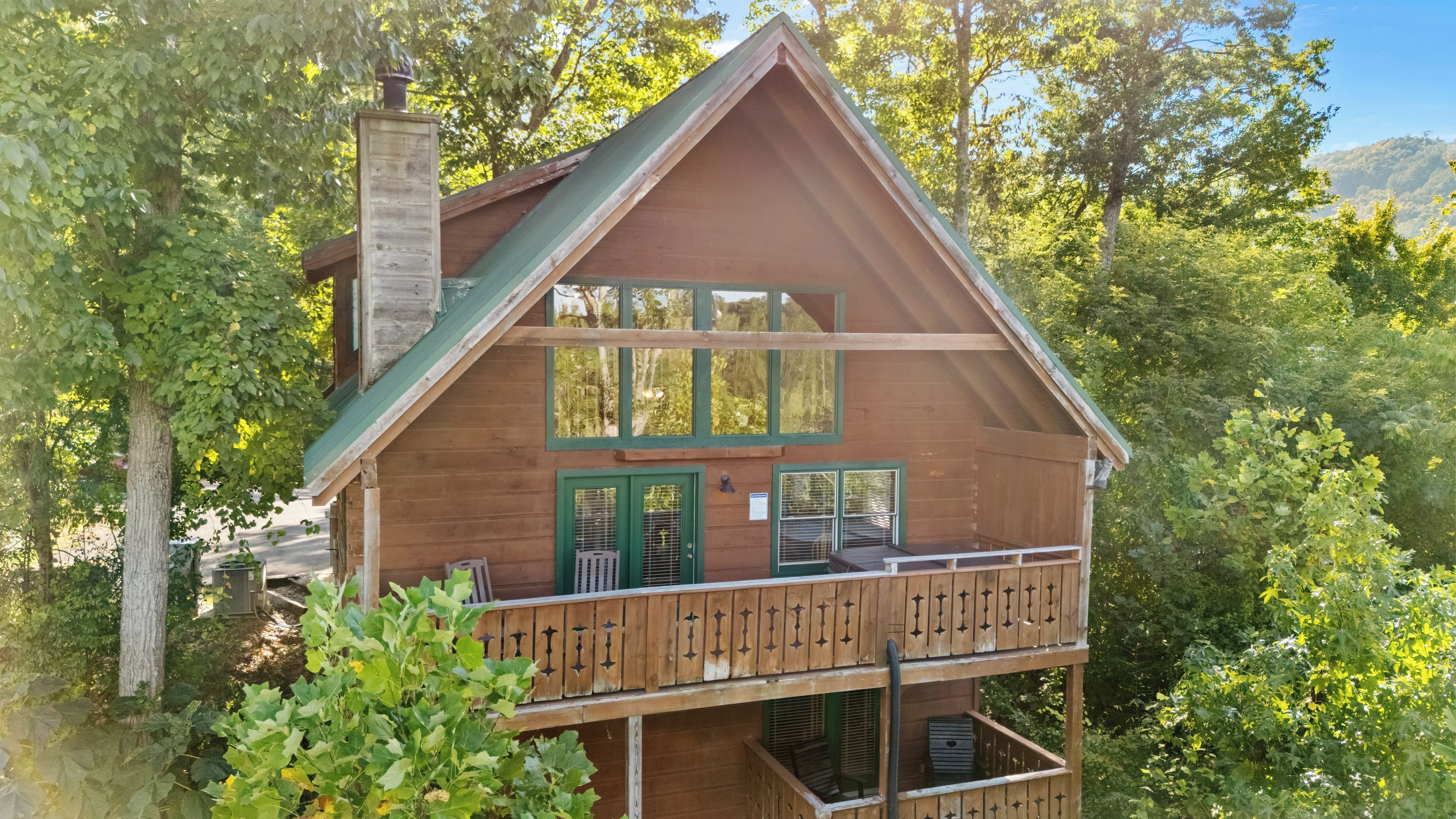Eine Holzhütte mit einem Balkon, umgeben von Bäumen.