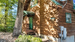 A wooden cabin with a green door, a small porch, and a number '390' on the wall.
