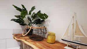 A wooden countertop with a woven basket, a yellow jar, and a small sailboat model. - No. 28 Contemporary Beach Side Property With sea Views (Chichester)