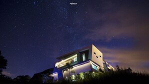 Une maison moderne sous un ciel étoilé.
