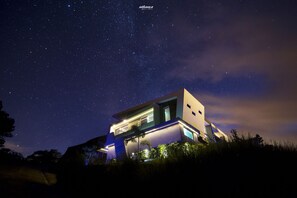 Une maison moderne sous un ciel étoilé.