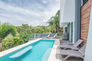 A swimming pool with lounge chairs, a grill, and a view of greenery. - Luxury Villa #10 Private Pool, Oceanview, & Complimentary Concierge Services (Playa Hermosa)