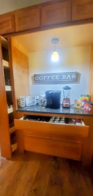 Un coin cuisine avec un panneau indiquant un bar à café, une machine à café, un mixeur et un four à micro-ondes.