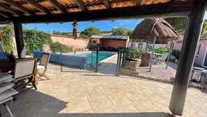 An outdoor patio area with a swimming pool, covered seating, and a small gazebo. - Charming property surrounded by vineyards near St Chinian (Pierrerue)