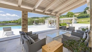 An outdoor patio area with a pool, seating, and a view of the landscape. - Villa la Duccia - Homelike Villas (Monterubbiano FM)