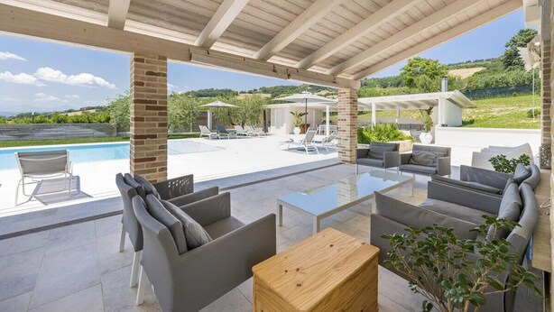 An outdoor patio with a pool, seating area, and a view of the landscape. - Villa la Duccia - Homelike Villas (Monterubbiano FM)