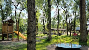 A playground with a slide, swings, and a circular play structure.