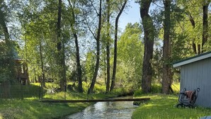 A riverside setting with a bench and a shed.